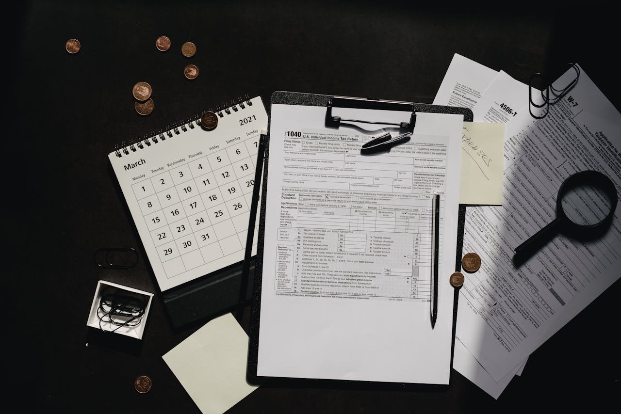 A neatly organized workspace featuring tax forms, calendar, magnifying glass, and office supplies for efficient tax preparation.