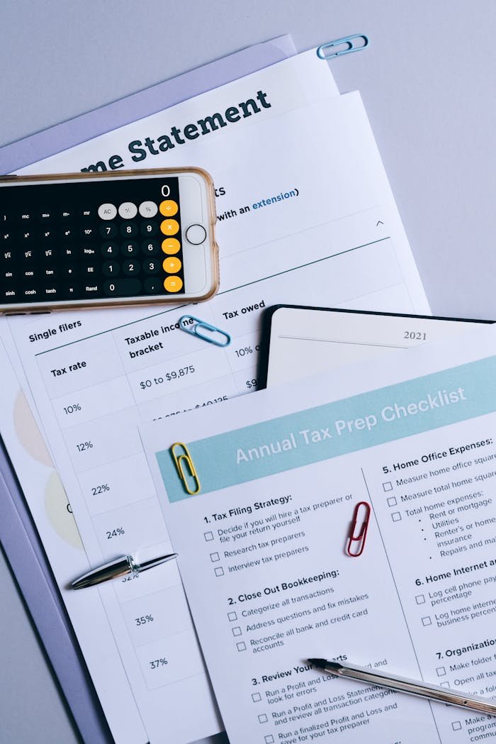 Flat lay of financial documents, tax checklist, and calculator for tax prep.